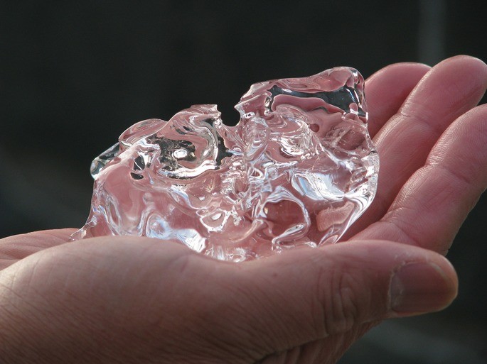 the ice melts by the conduction of the heat of the hand
