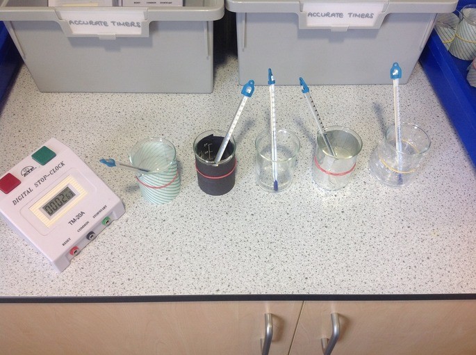 several beakers with thermometers